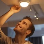 man changing a light bulb while doing household tasks